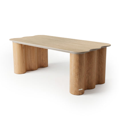 Modern wooden table with rounded corners and sculptural cylindrical legs on white background