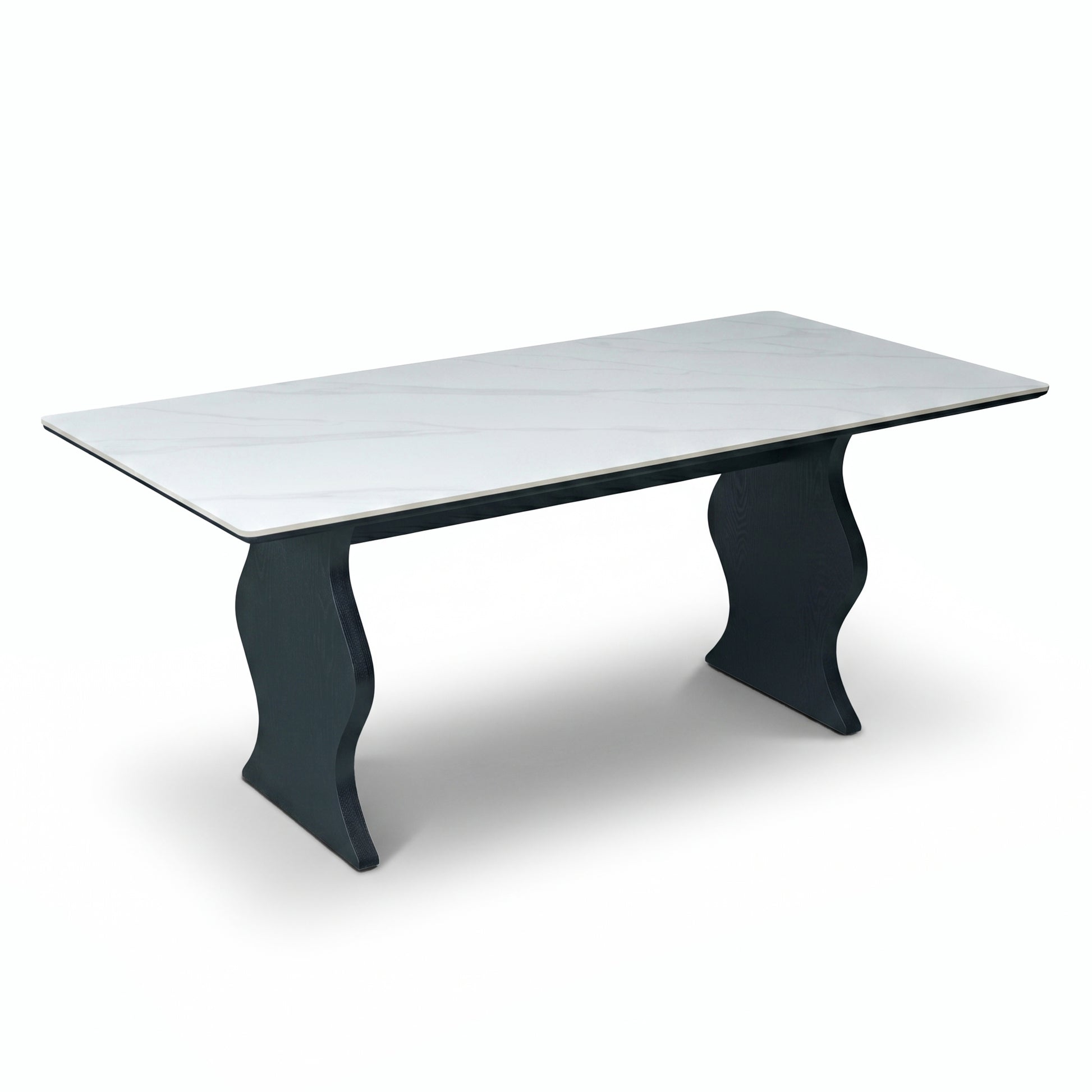 Modern rectangular table with white top and sculptural black legs on a white background