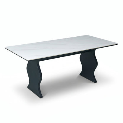 Modern rectangular table with white top and sculptural black legs on a white background