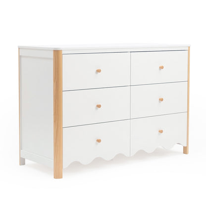 White six-drawer dresser with light wood corners and scalloped bottom on a white background