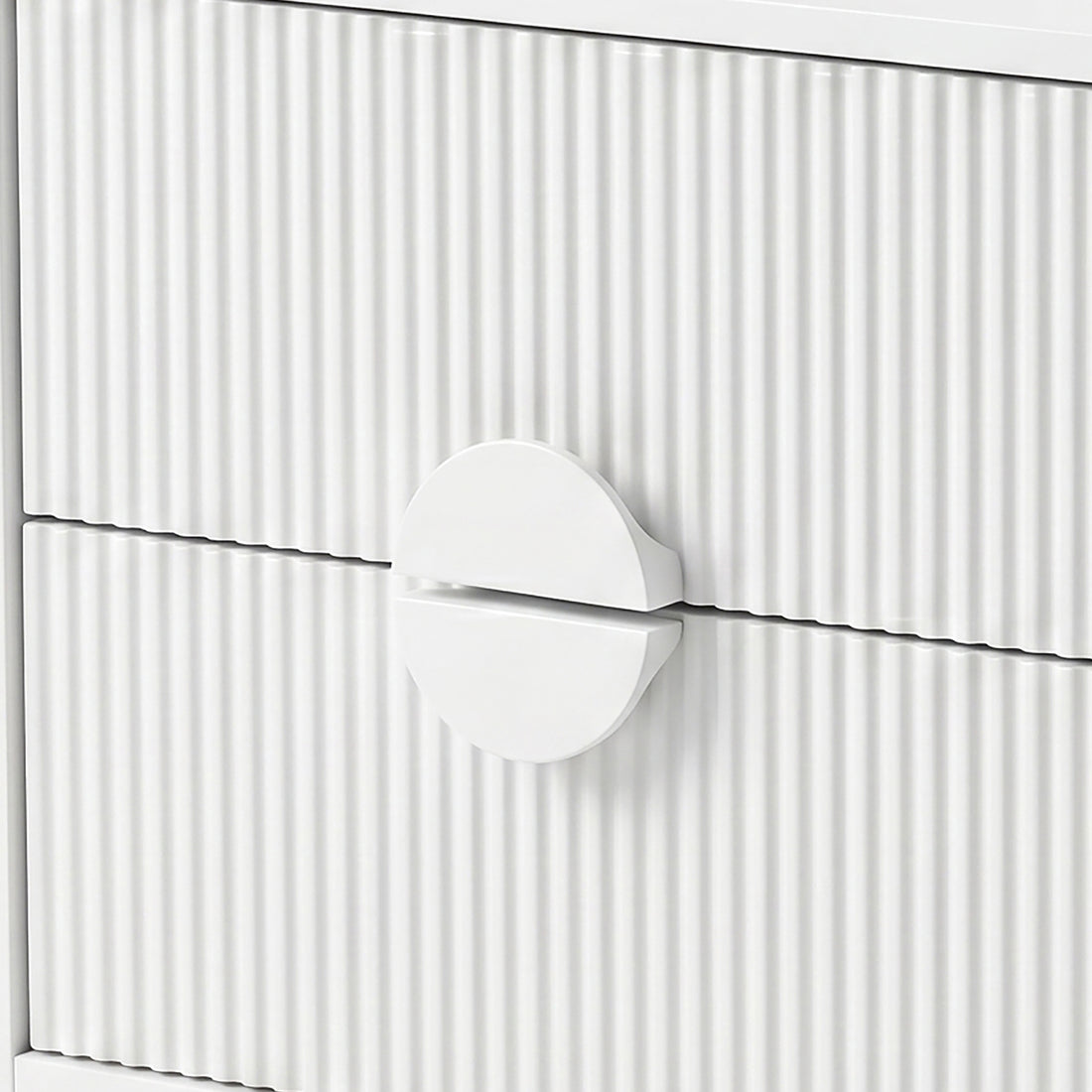 Close-up of white drawer fronts with vertical grooves and circular handle
