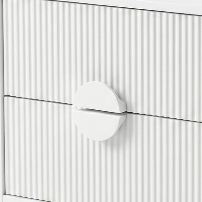 Close-up of white drawer fronts with vertical grooves and circular handle