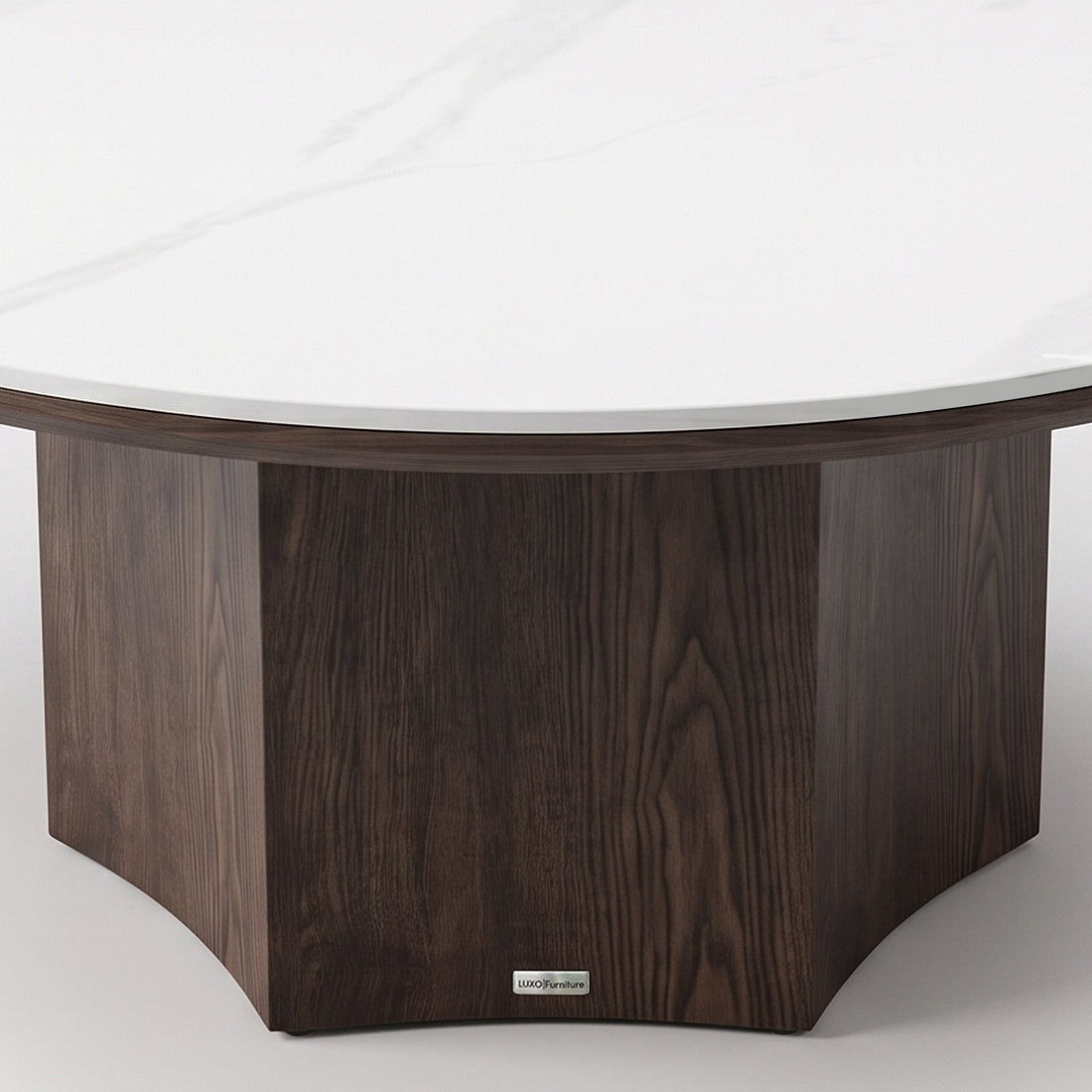 Partial view of a round table base and tabletop with dark wood and white marble-style finish on a white background