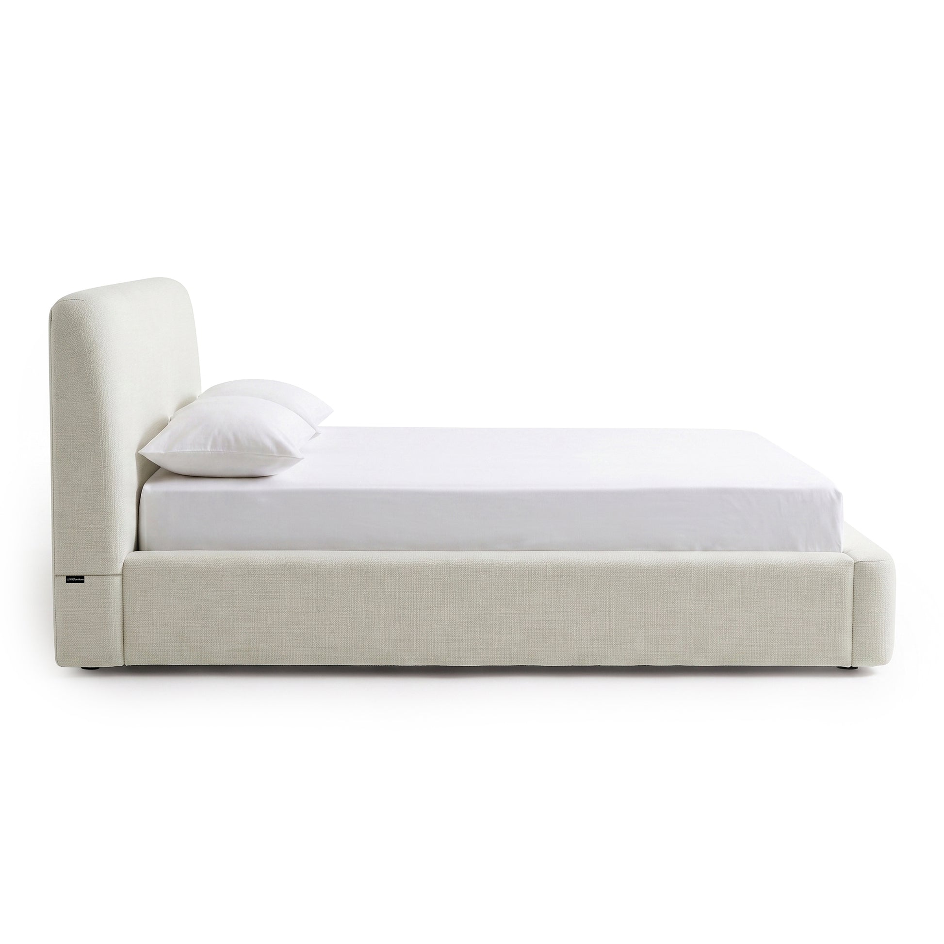 Side view of a modern upholstered bed on a white background