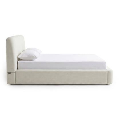 Side view of a modern upholstered bed on a white background