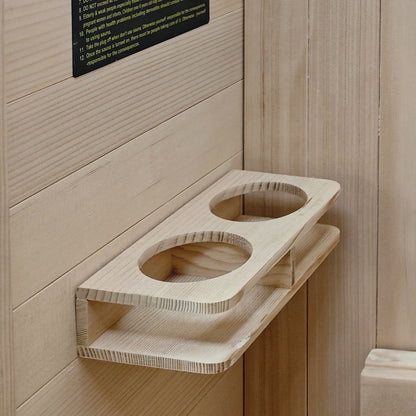 Wooden cup holder shelf mounted on a light wood sauna wall