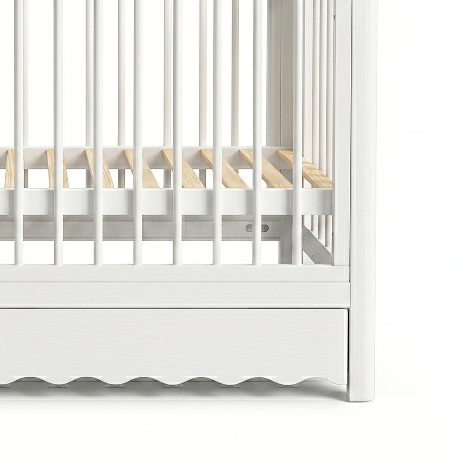 Close-up of crib base, slats, and scalloped drawer edge