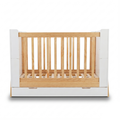 Front view of crib with wood slats and white side panels