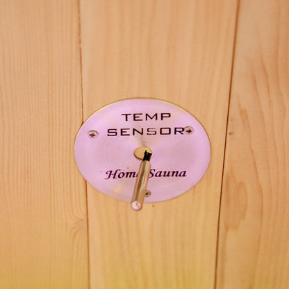 Close-up of a temperature sensor labeled Home Sauna mounted on a wooden wall