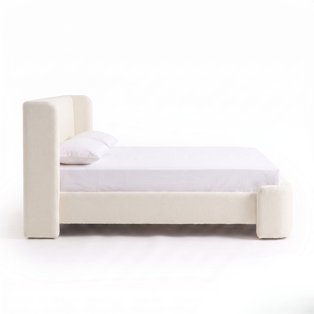 Side view of a full upholstered bed on a white background