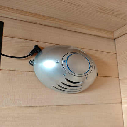Compact oval electronic control device mounted on a wooden wall.