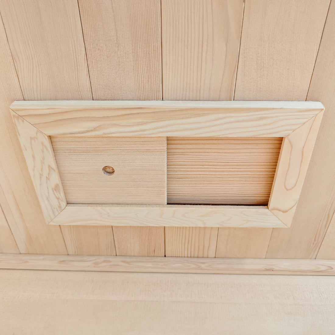 Wooden sliding panel installed in a wood-paneled wall