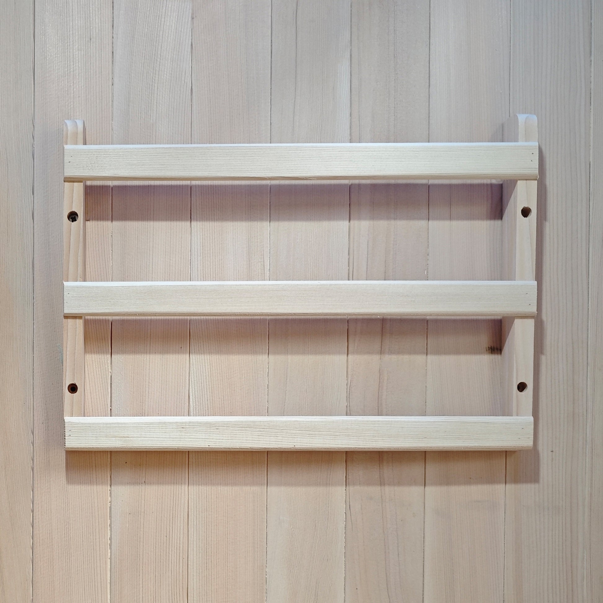Small wooden wall-mounted rack on a wood-paneled wall.