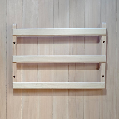 Small wooden wall-mounted rack on a wood-paneled wall.