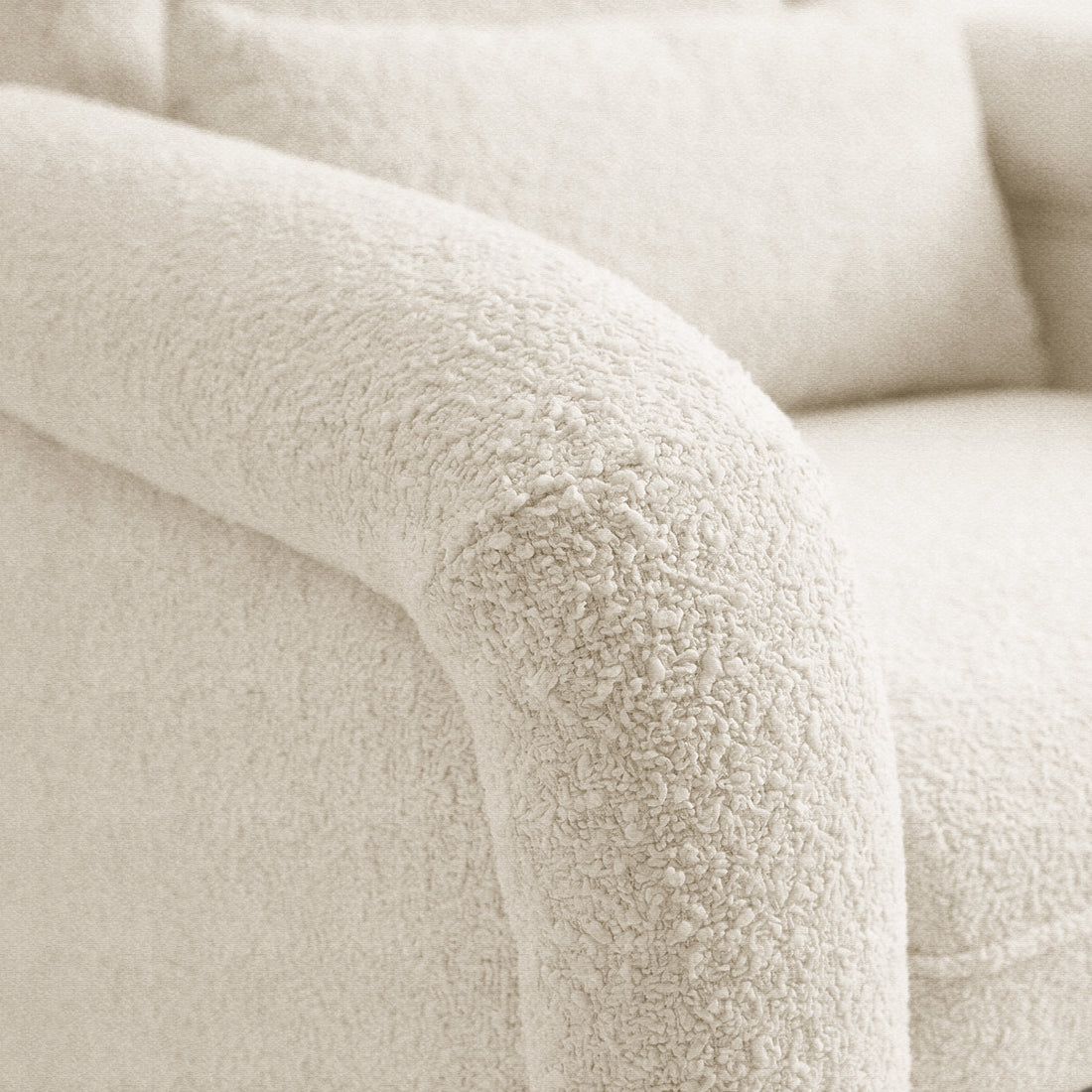 Close-up of upholstery texture of cream-colored armchair in room