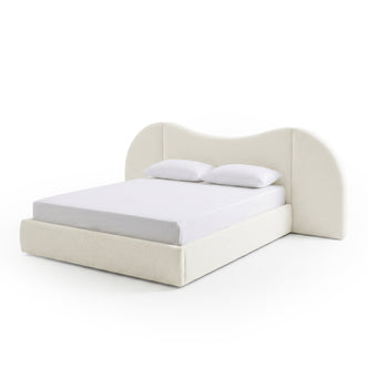 Modern upholstered bed with curved headboard and pillows on white background