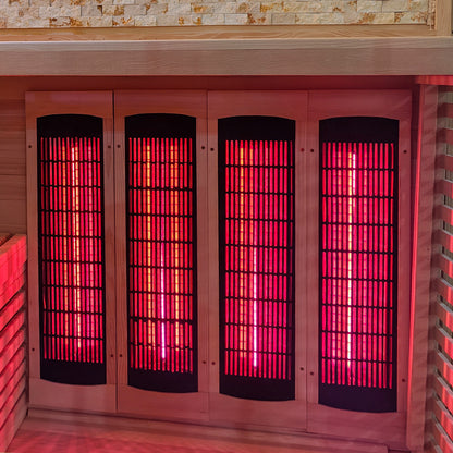 Infrared heating panels glowing red inside a wooden sauna interior.