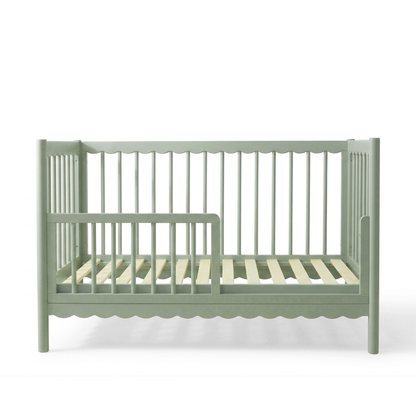 Sage green children's crib on white background