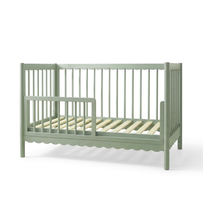 Sage green convertible crib on white background