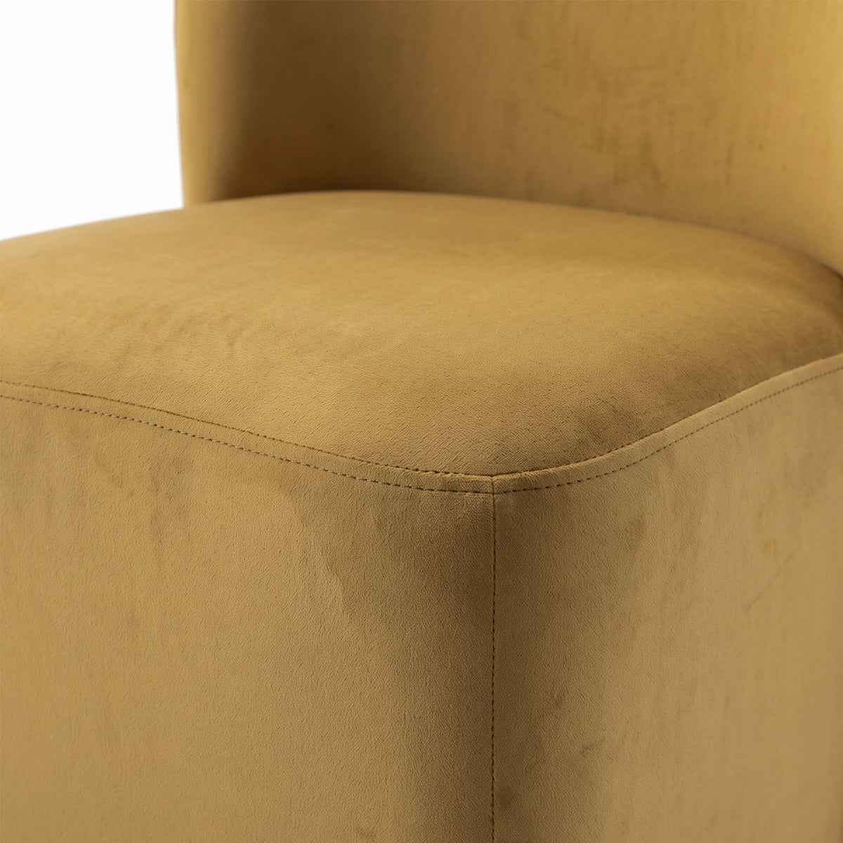 Close-up of mustard upholstered chair seat and stitching detail