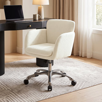 Cream upholstered office chair in a home office beside a desk and lamp