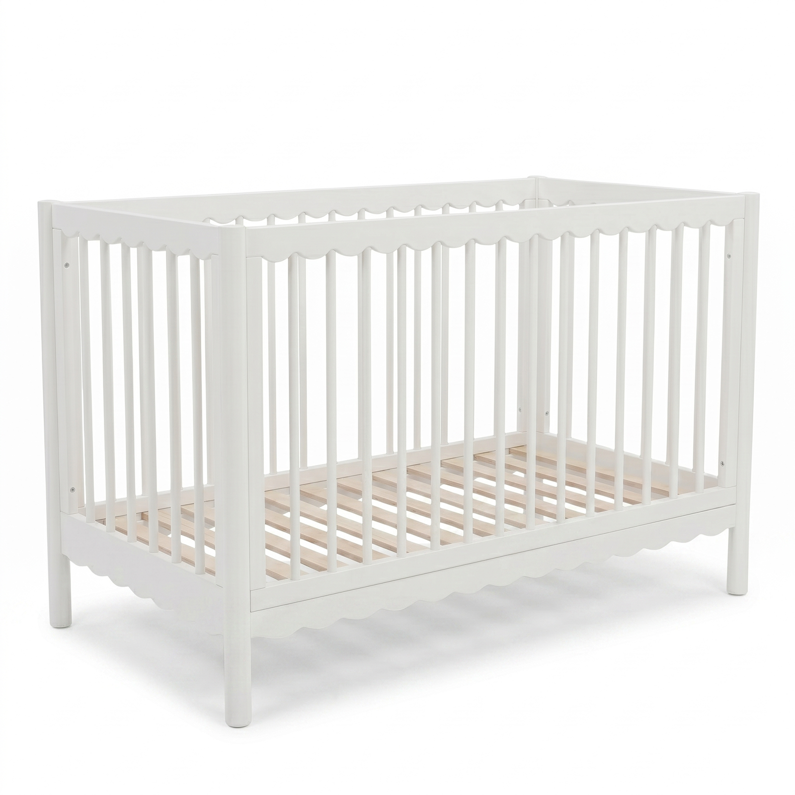 White crib with scalloped detailing on a white background