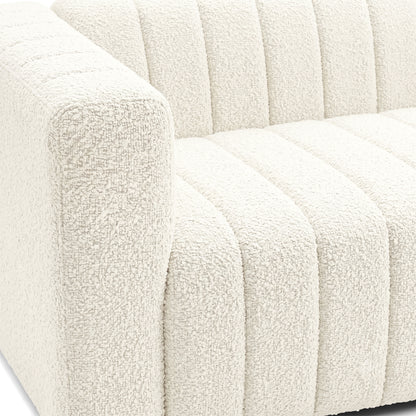 Close-up of the left side and seat of a cream textured sofa