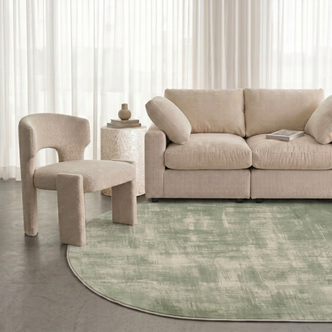 Modern living room with a green patterned rug, sofa, and accent chair