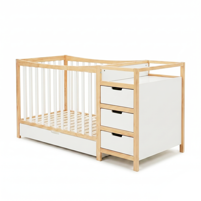 Modern baby crib with integrated changing table and drawers on a white background
