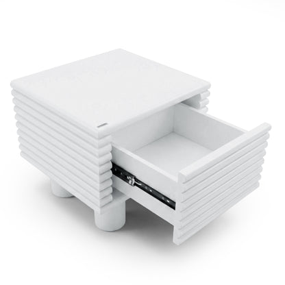 White modern nightstand with ribbed sides and partially open drawer on white background
