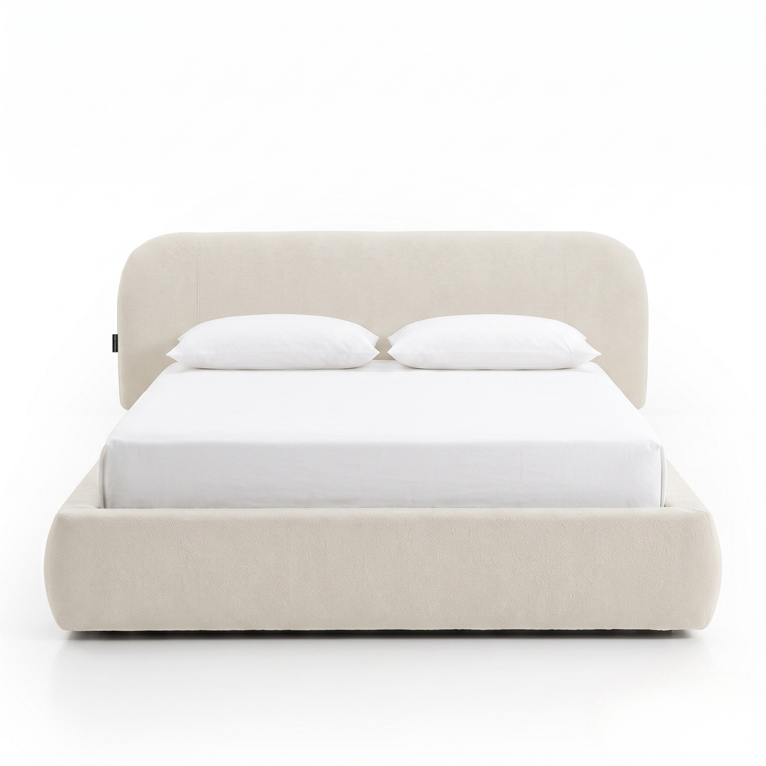 Modern upholstered bed with pillows on a white background