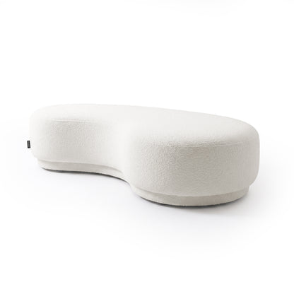Kidney bean-shaped cream white upholstered bench seat on a white background