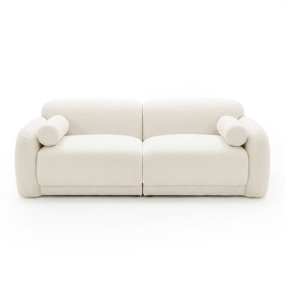 Off-white sofa with rounded arms and cylindrical cushions on white background