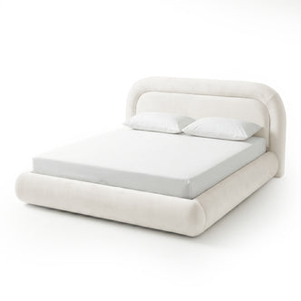 Upholstered king-size bed frame with mattress and pillows on white background