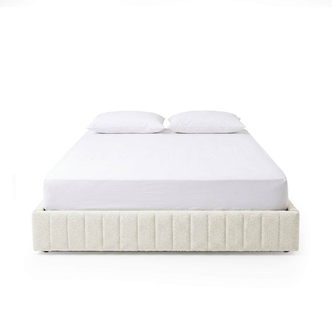 Modern bed frame with vertical channel upholstery and two white pillows on a white background