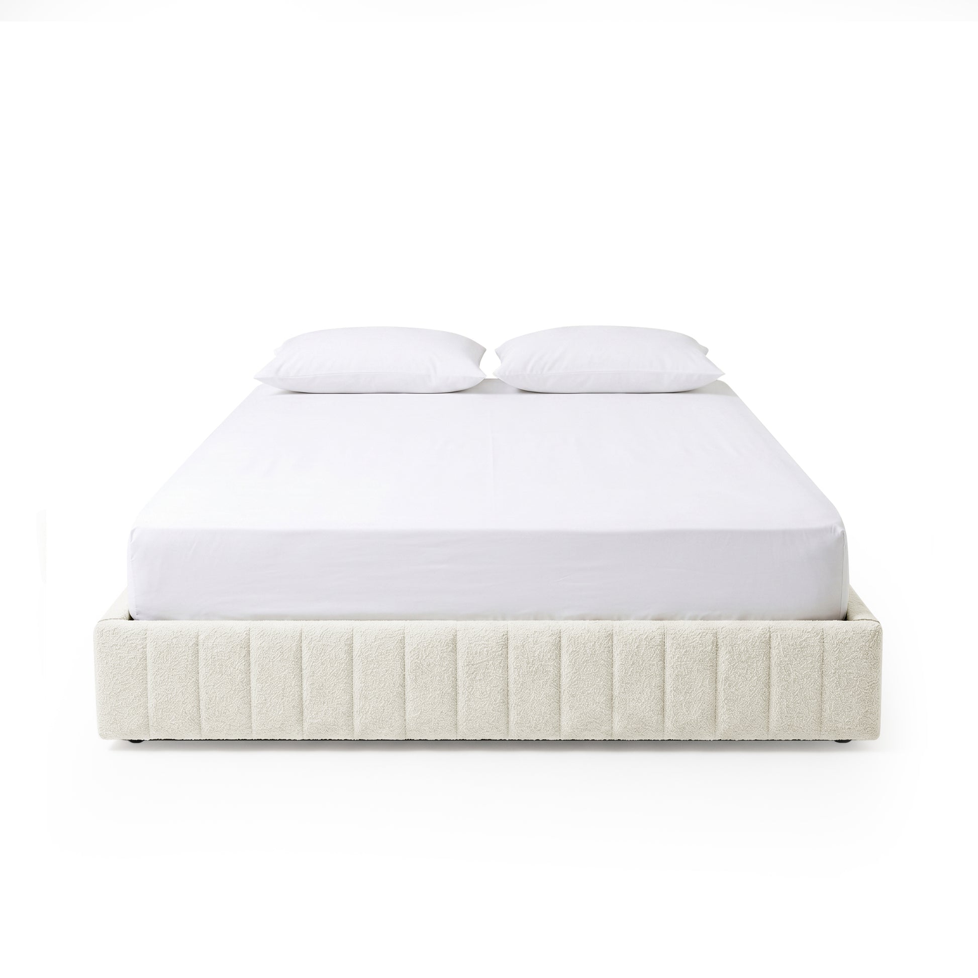 Modern bed frame with vertical channel upholstery and two white pillows on a white background