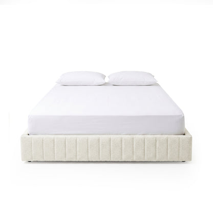 Modern bed frame with vertical channel upholstery and two white pillows on a white background