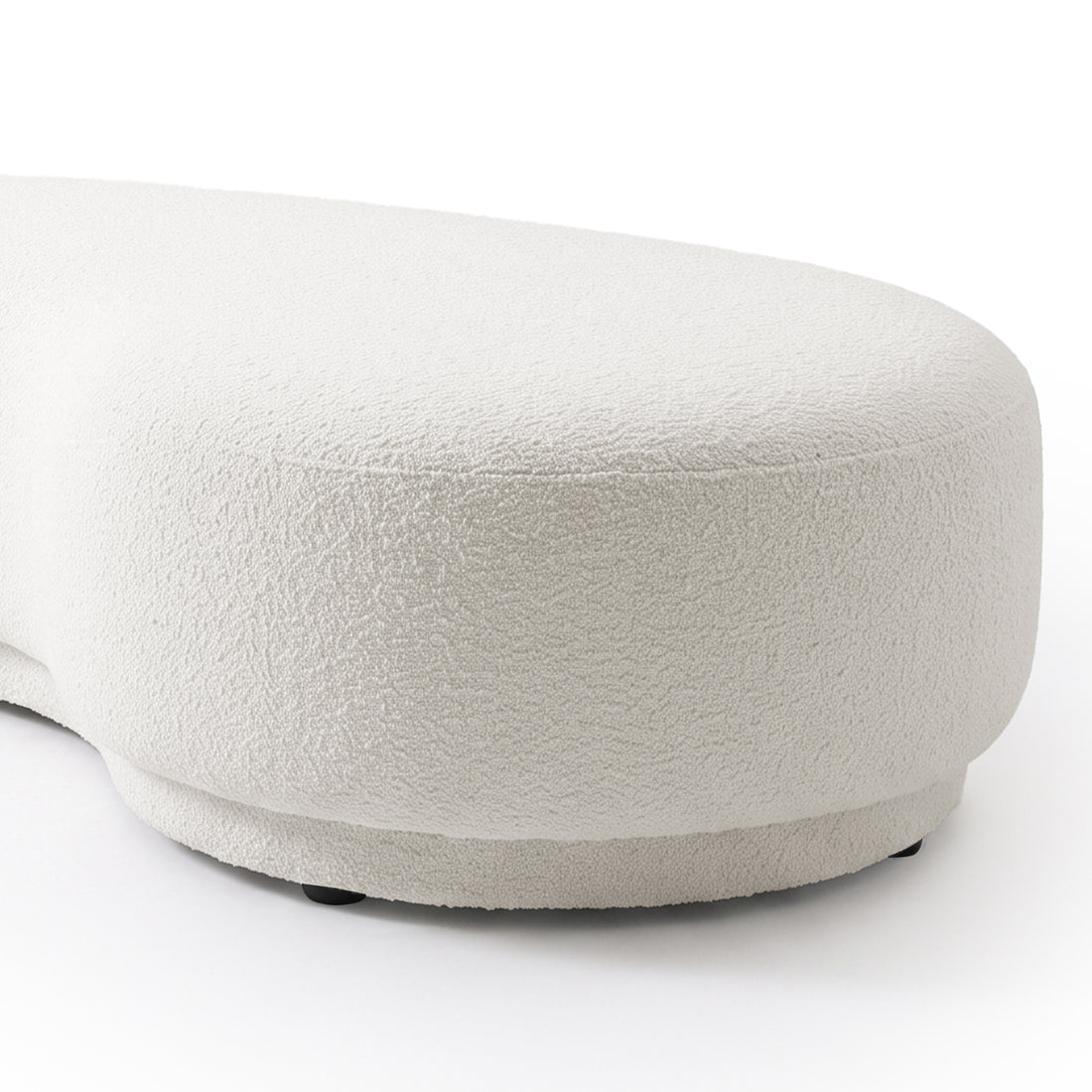 Close view of a curved cream white upholstered furniture piece on a white background