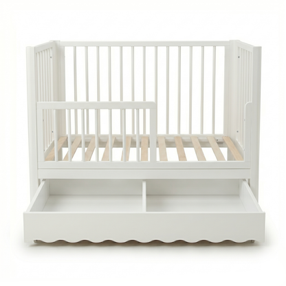 White convertible baby crib with underbed storage drawer on white background