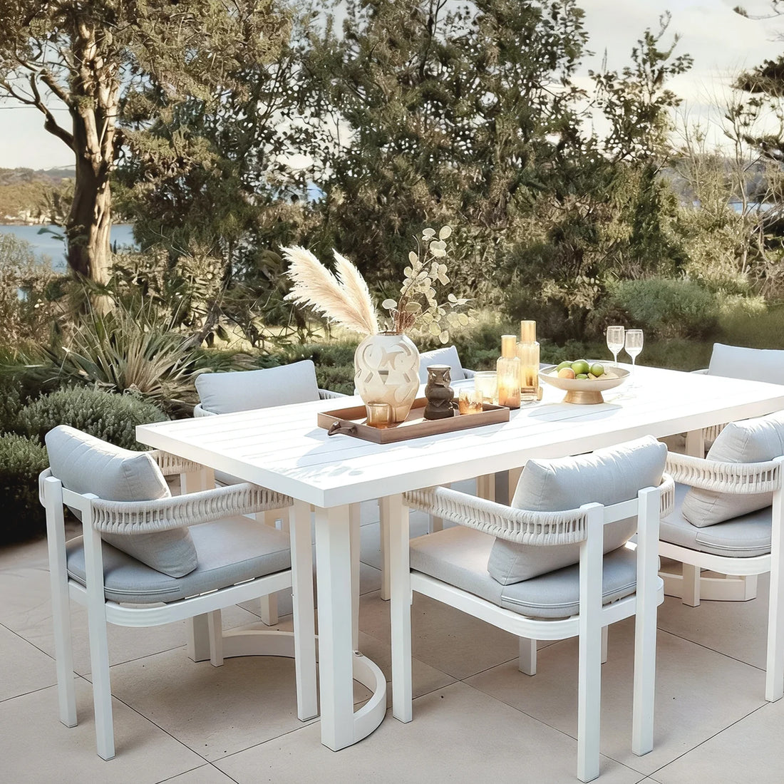 Outdoor patio dining set with table and six chairs by the water