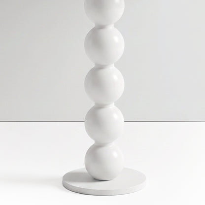 Close-up partial view of stacked white spheres on a furniture base against a white background
