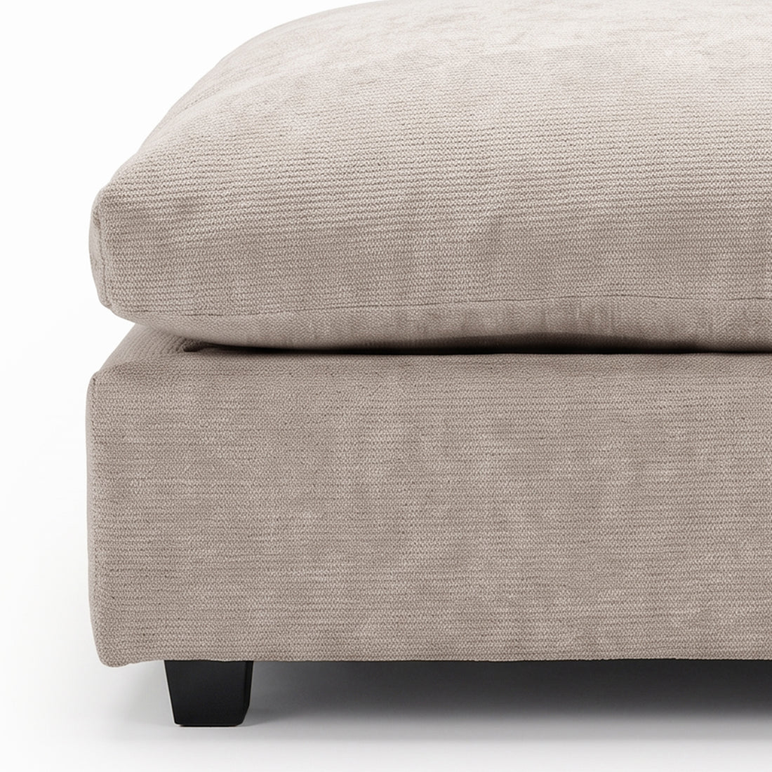 Close-up front view of beige upholstered ottoman section on a white background.