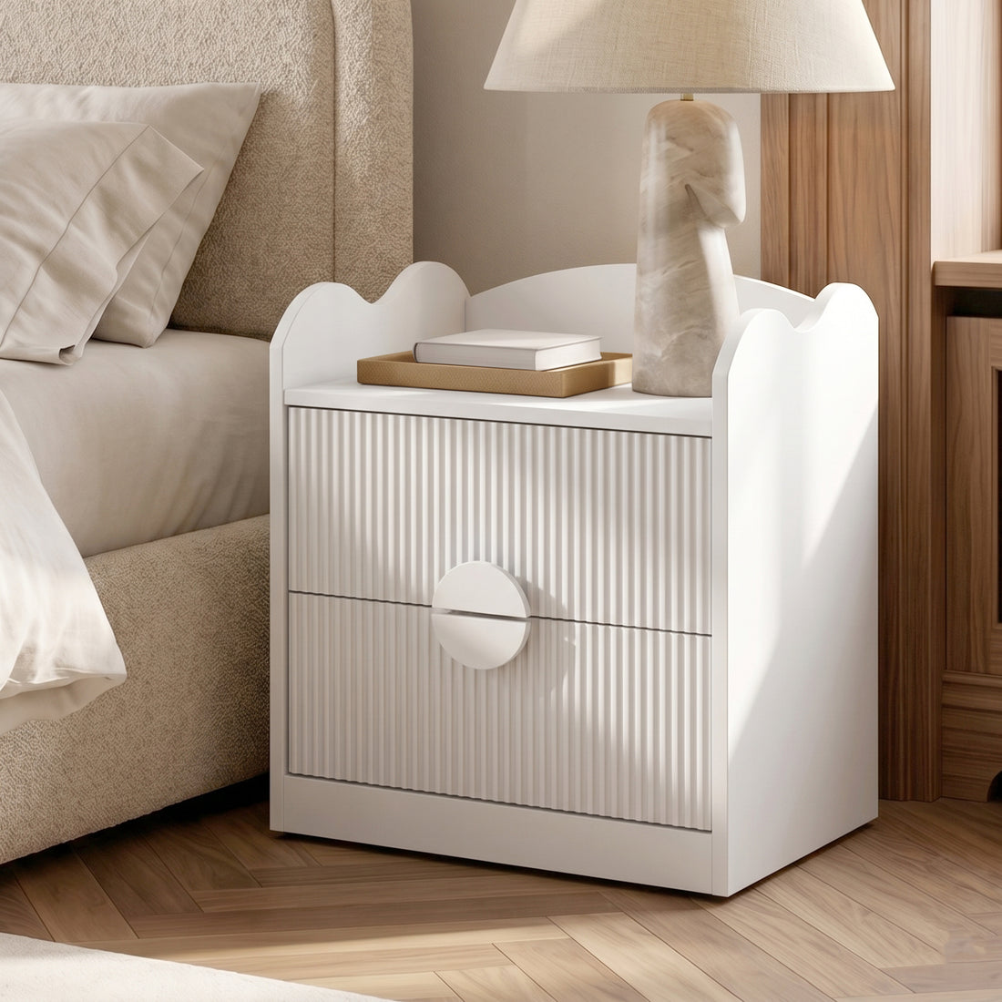 White bedside table in a styled bedroom with lamp and decorative tray
