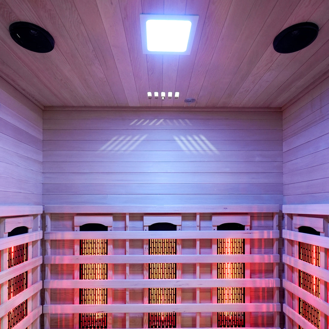 Interior view of a wooden infrared sauna with glowing heating panels