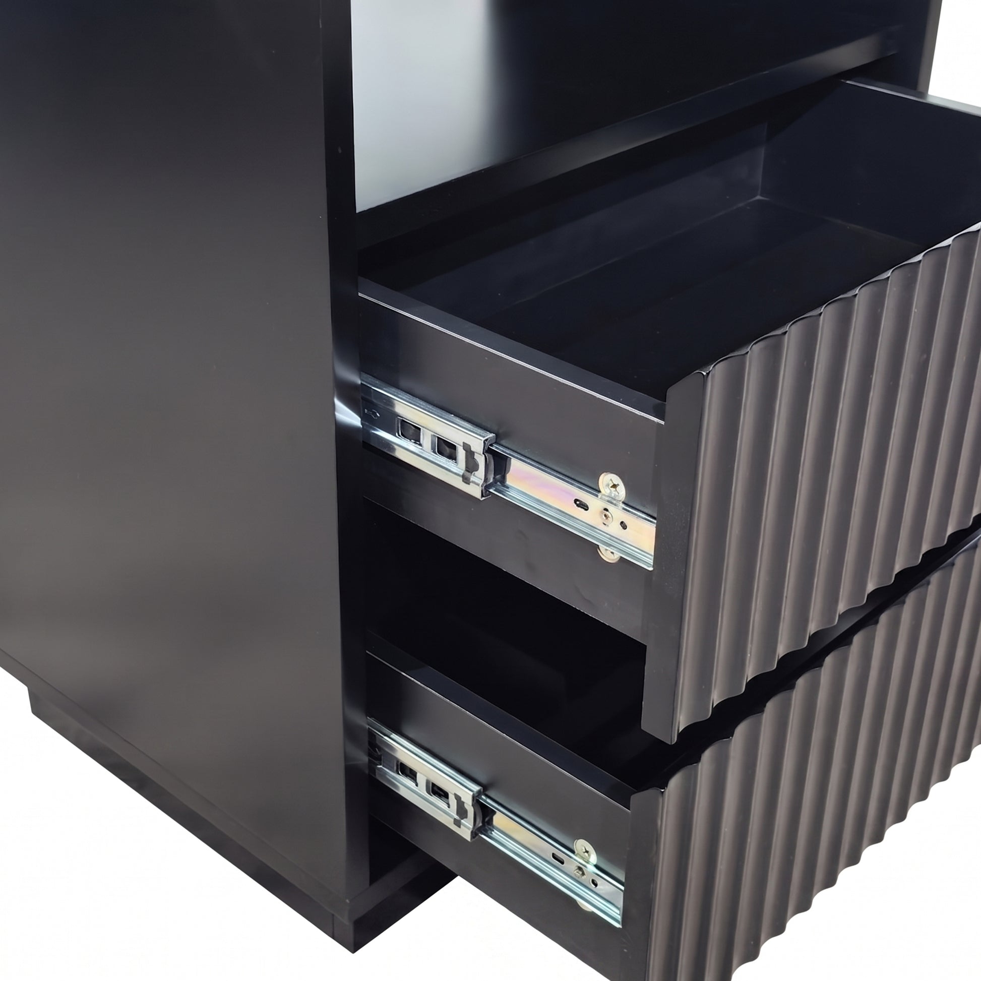 Close-up of partially opened drawers on a black cabinet against a white background