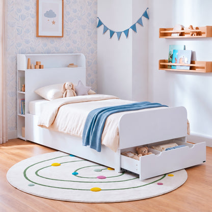 White children's bed with storage drawer and shelf headboard in a bright kid's room.