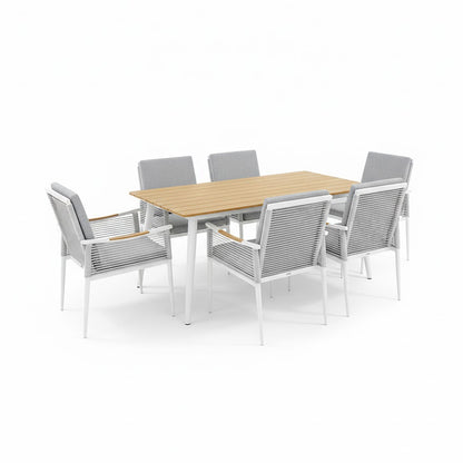 Casara 7 Piece Outdoor Dining Set in White & Grey, featuring a rectangular wood-slatted table with white metal legs, six matching chairs with rope-woven sides, and light gray cushions.
