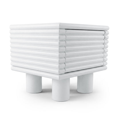 White ribbed side table with four cylindrical legs on white background