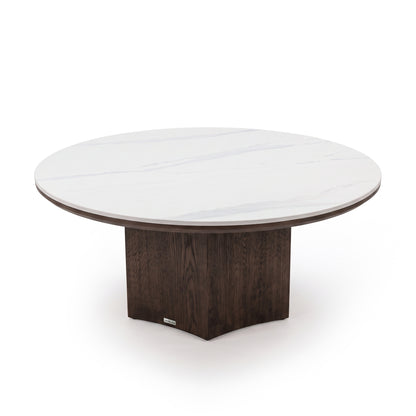 Round table with white marble-like tabletop and dark wooden pedestal base isolated on a white background.