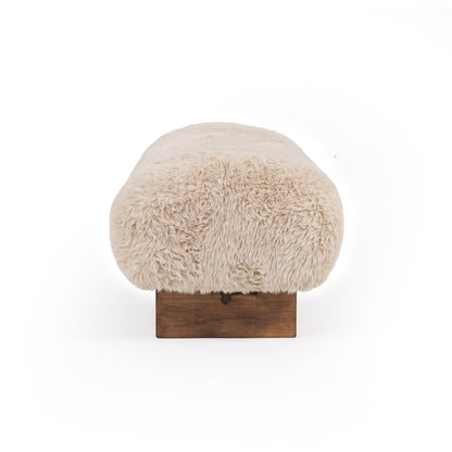 End view of a cream upholstered bench on a white background